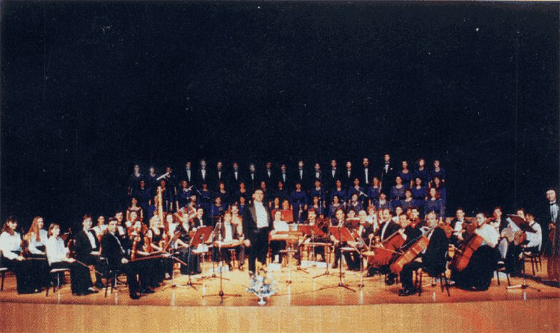 Sıcak sahne ışıkları altında performans yapan orkestra ve koro