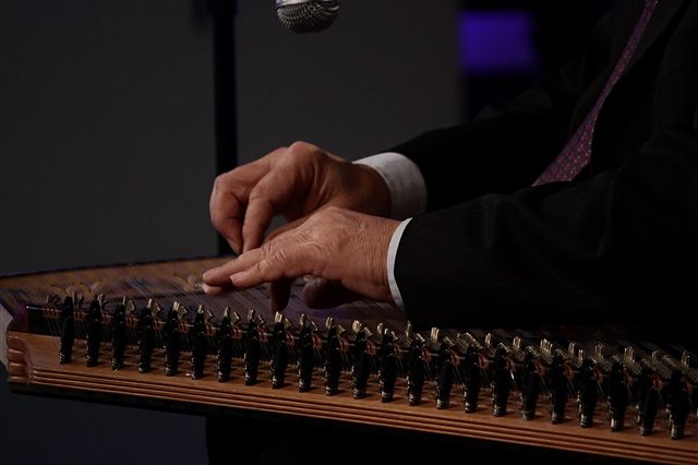 Close-up of hands playing a kanun on stage